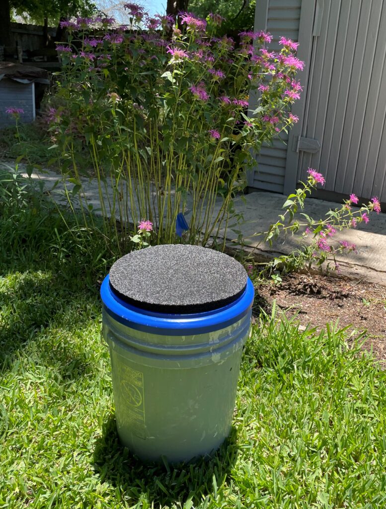 My sit-upon bucket.  With it's cushioned lid, I can work in comfort and with no bending over.