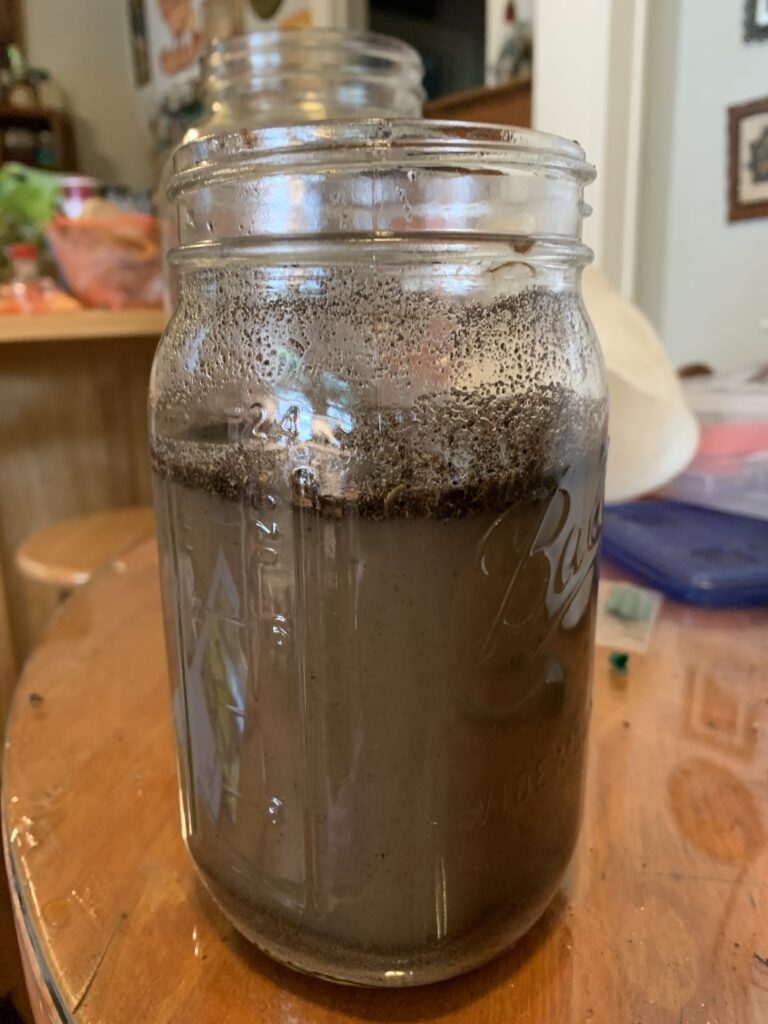 This photo shows a mason jar containing soil and water.  For the test you add 1 part soil to 5 parts water, shake thorooughly, and let sit for 24 hours.