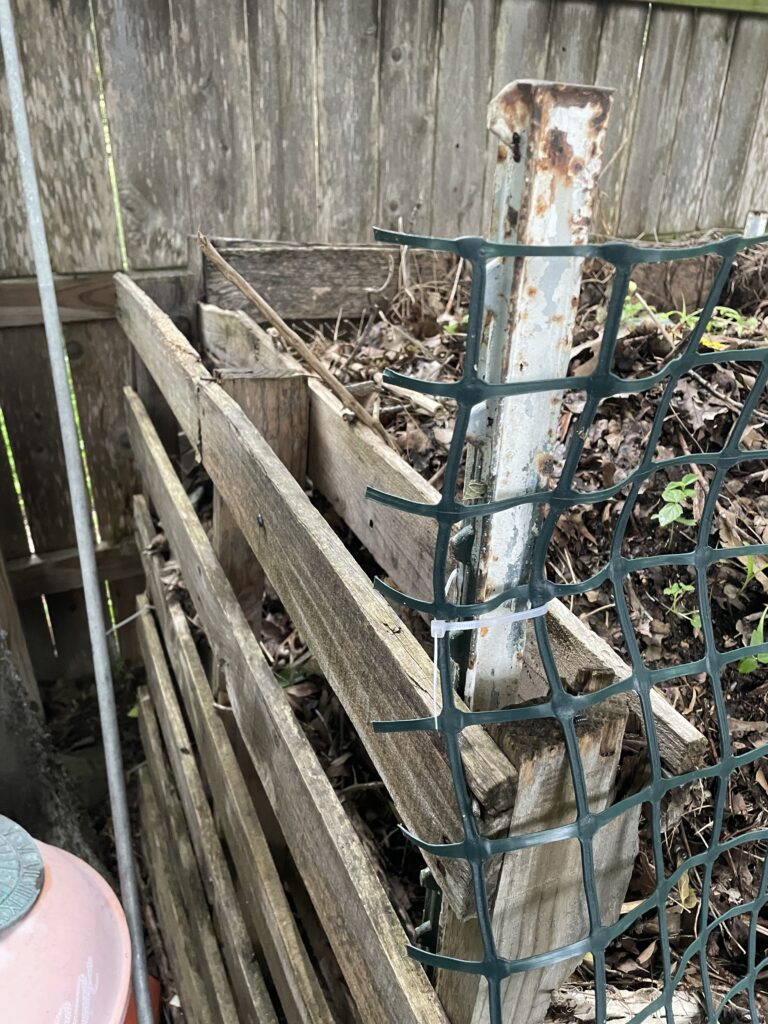 This photo shows the t-post  hammered into place between the layers of wood in the pallet.  This gives us the stability we need to keep the compost bin standing up.